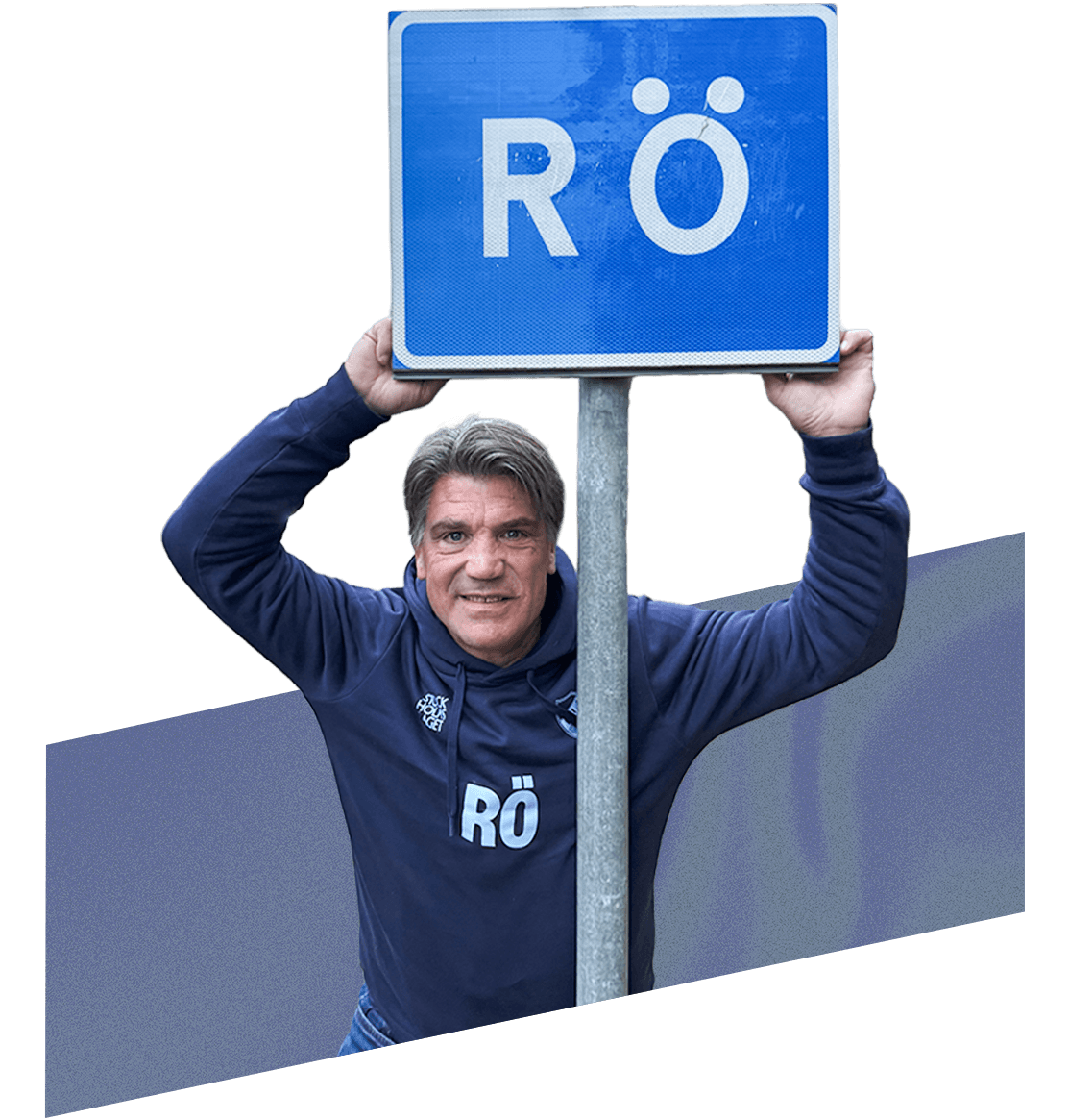 Bosse Andersson håller upp ortsskylten för Rö